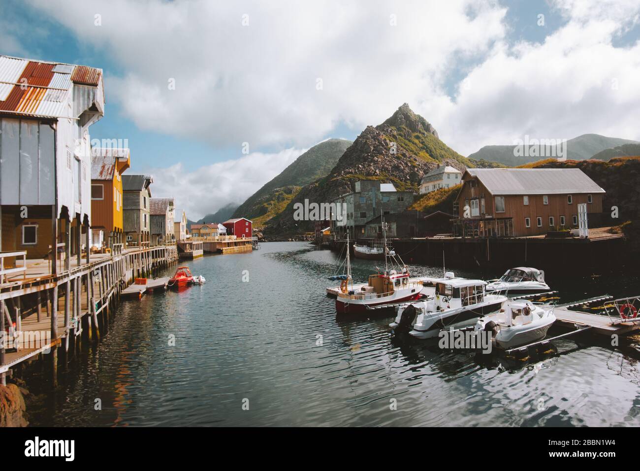 Nyksund villaggio di pescatori in Norvegia tradizionale architettura case in legno rorbu e fiordo con montagne scandinave destinazioni di viaggio paesaggio Foto Stock