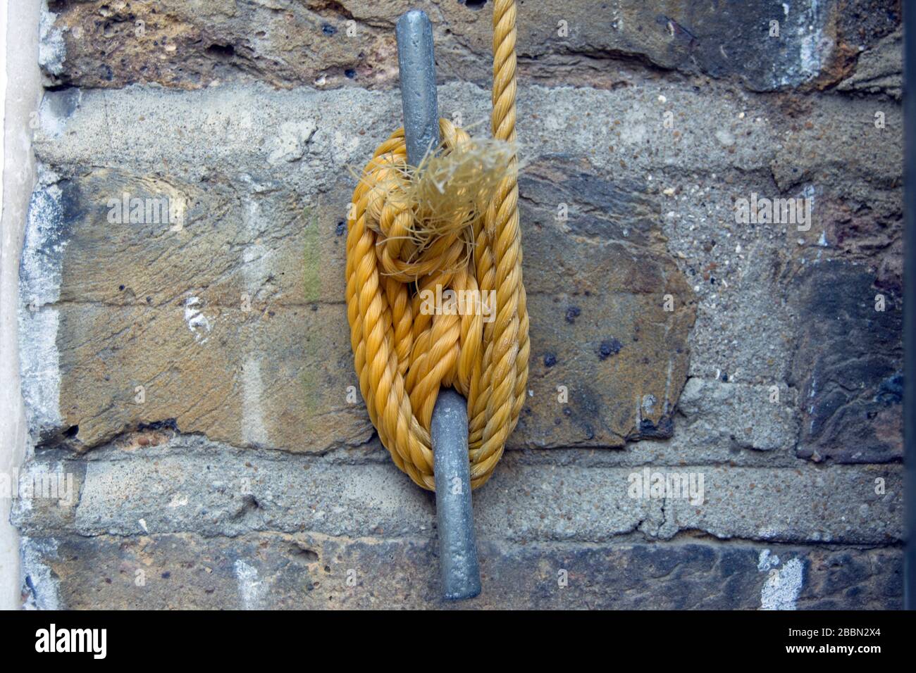 fune in nylon con filo di lavaggio avvolta intorno ad un gancio di chiusura fissato a una parete in mattoni Foto Stock