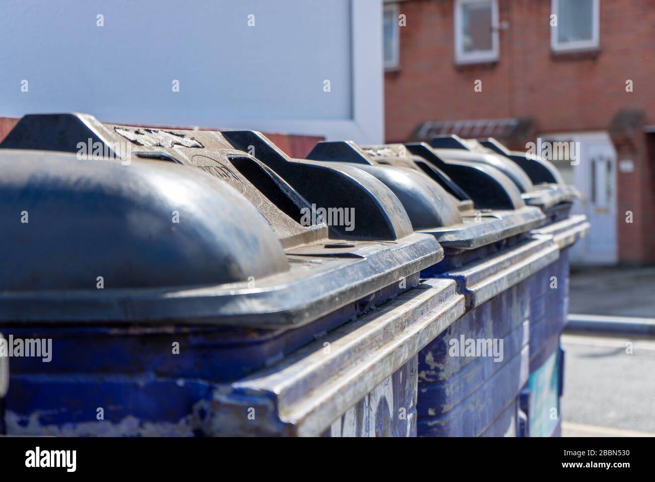 Una fila di bidoni delle bottiglie nella strada con la messa a fuoco su un bidone Foto Stock