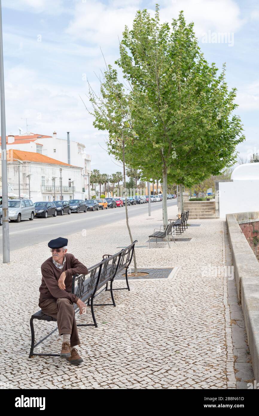 Uomo seduto in panchina pubblica, Silves, Algarve, Portogallo Foto Stock