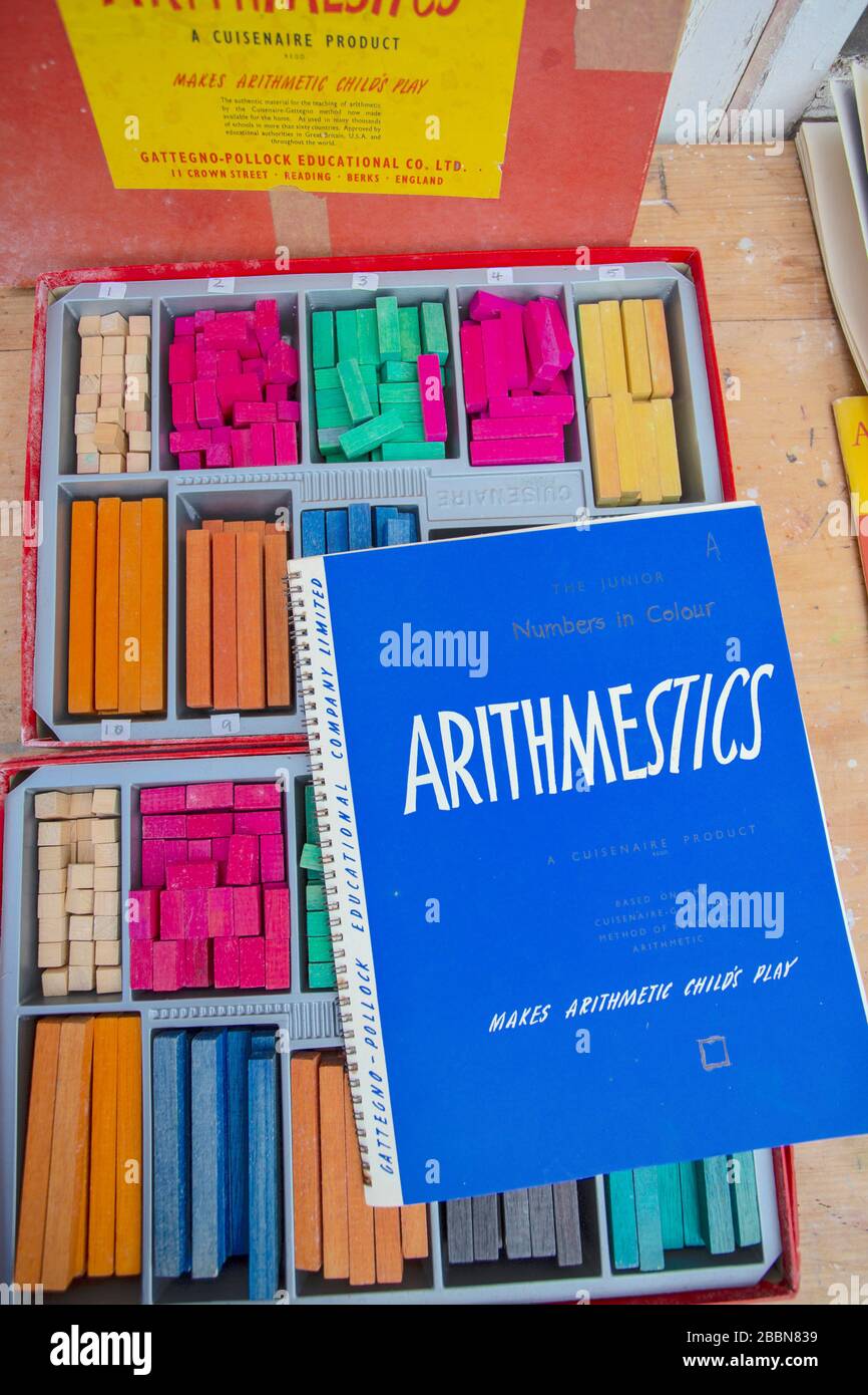 1st Aprile 2020 Vintage Cuisenaire aste di conteggio in legno e libri di accompagnamento con sfide matematiche per aiutare l'apprendimento Foto Stock