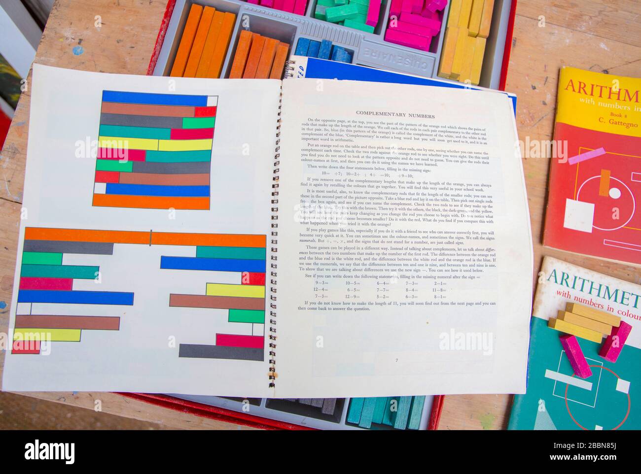 1st Aprile 2020 Vintage Cuisenaire aste di conteggio in legno e libri di accompagnamento con sfide matematiche per aiutare l'apprendimento Foto Stock