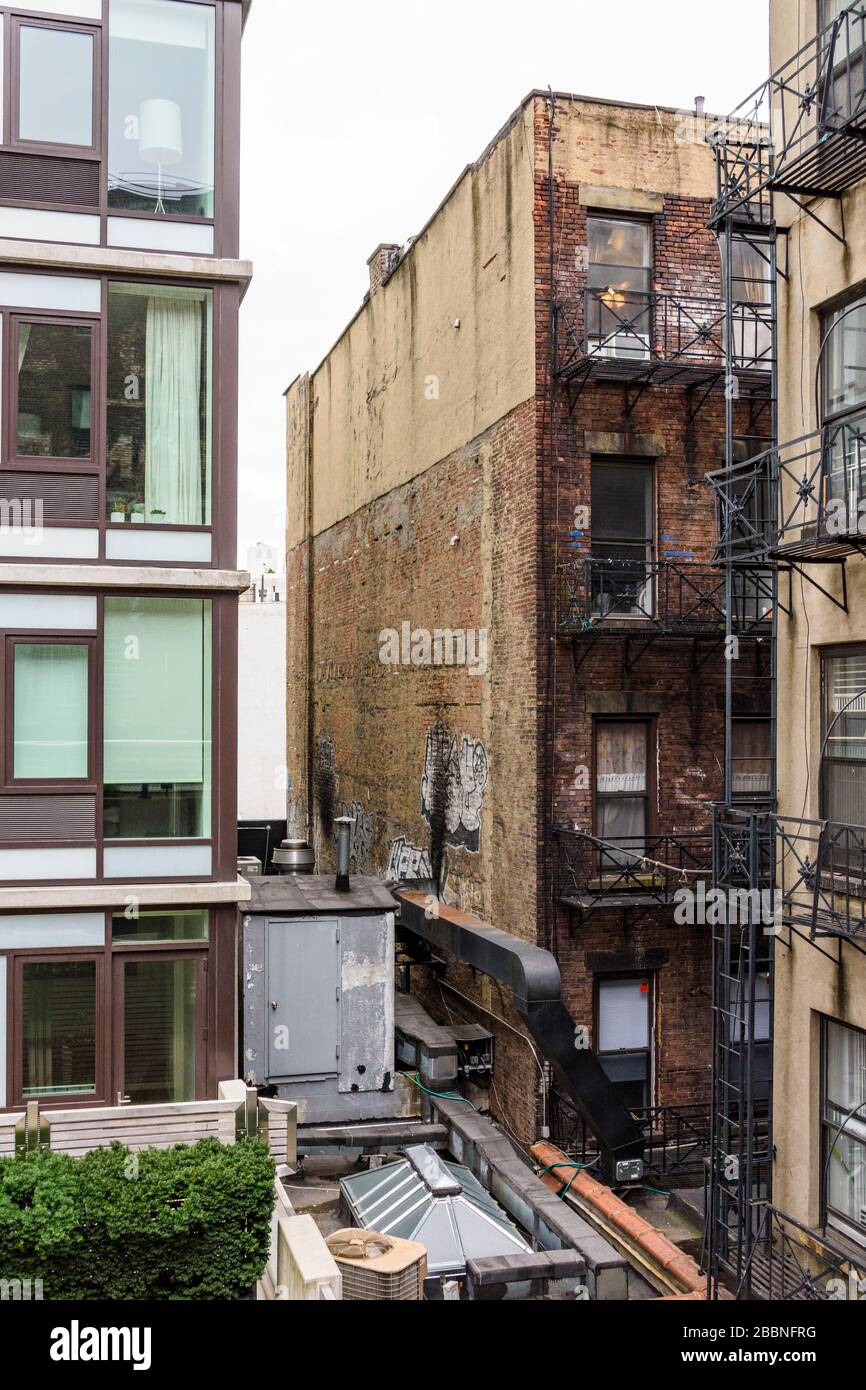 Giustapposizione di vecchi e nuovi appartamenti visti dalla High Line di New York Foto Stock