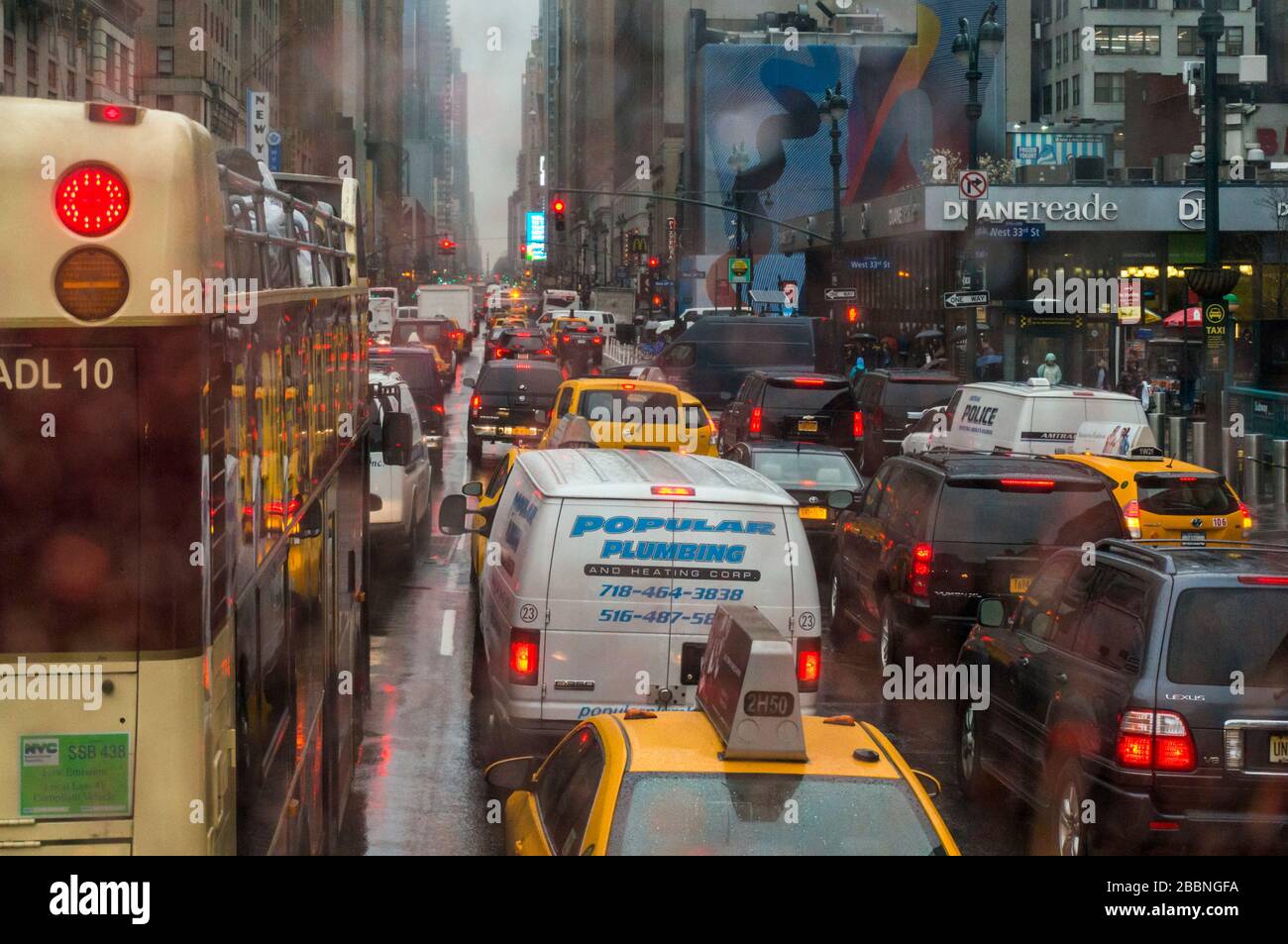 Traffico bloccato su strada 8th Avenue e West 33rd Street a New York in una giornata piovosa Foto Stock