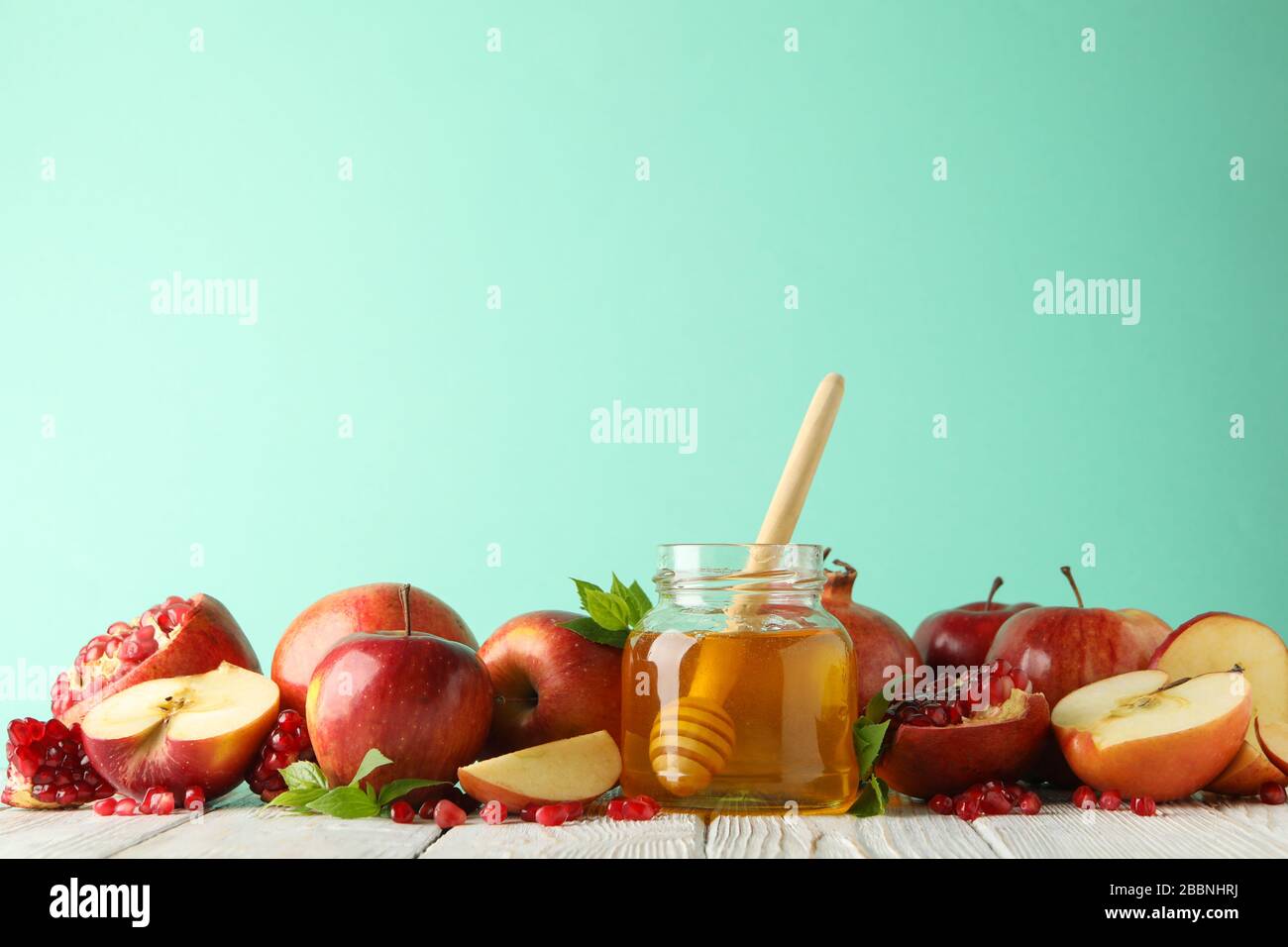 Mele, melograno e miele sullo sfondo della menta, spazio per il testo Foto Stock
