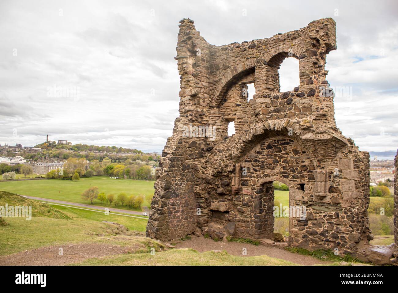 La rovina della Cappella di Sant’Antonio a Holyrood Park, con Calton Hill sullo sfondo, fotografata presto in una giornata di lancio a Edimburgo Foto Stock