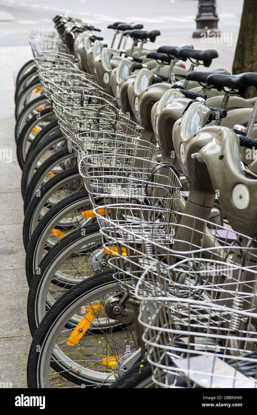 Fila di biciclette parcheggiate in affitto nella strada di una moderna città europea Foto Stock