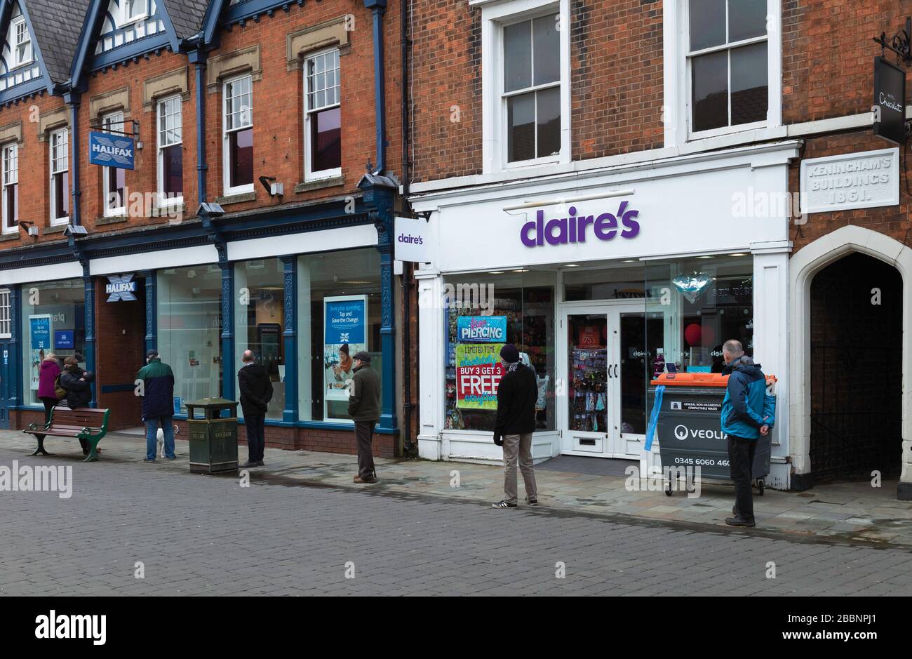 La gente fila il distributore di contanti della banca dopo la chiusura della maggior parte dei negozi durante lo scoppio del virus di Corona in Beverley, Yorkshire, Regno Unito. Foto Stock
