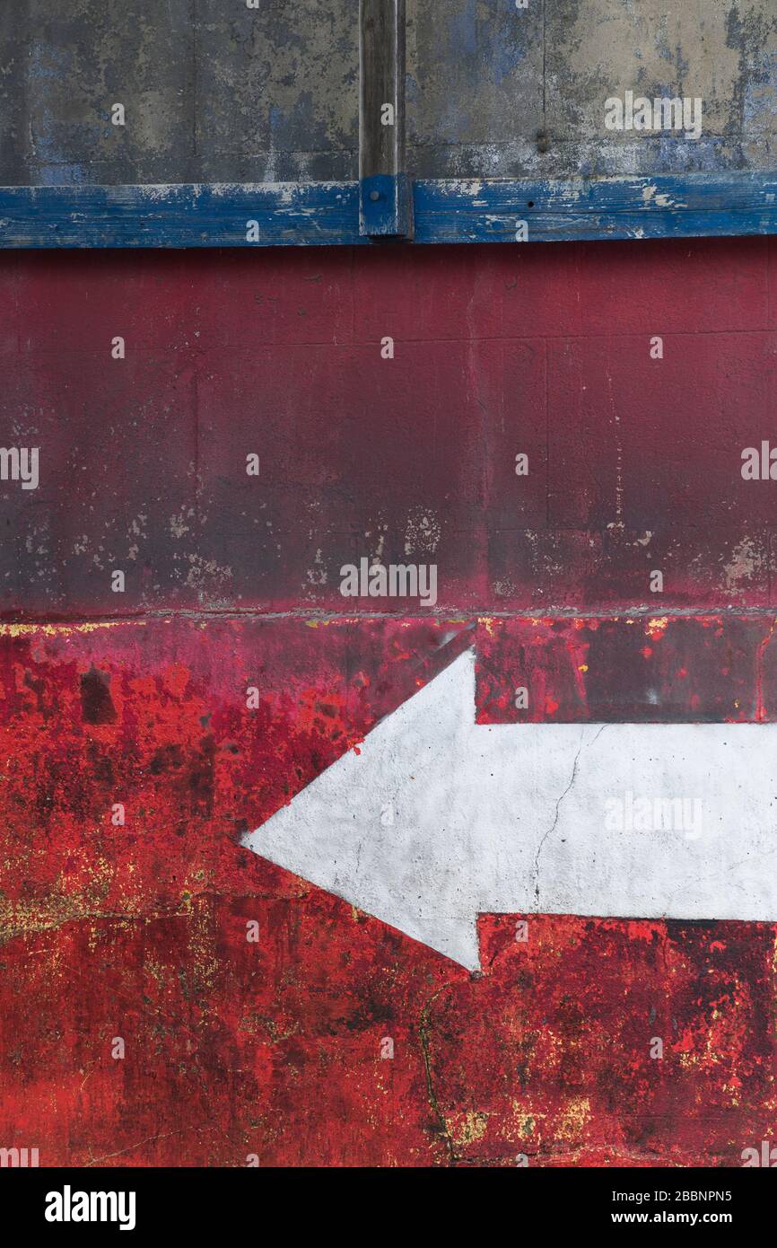 Freccia dipinta a mano su un muro in un autolavaggio, Highgate Road, Kentish Town, Londra, Regno Unito. Foto Stock
