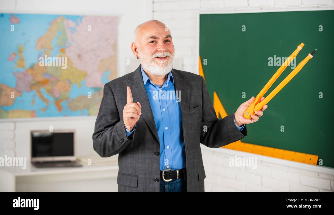 Revisione errori. Barbuto tutor uomo disegnare con bussola in lavagna. Torna a scuola. Concetto di strumenti grafici matematici. Verso la conoscenza. Studia matematica per ottenere buoni risultati. L'insegnante senior usa lo strumento bussola. Foto Stock