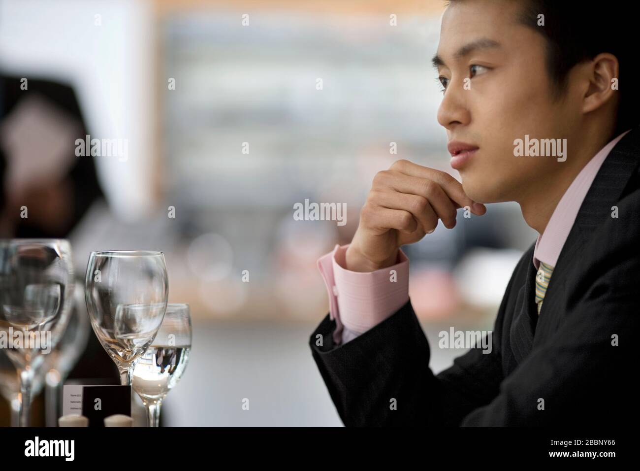 Uomo d'affari giovane adulto seduto ad un tavolo in un ristorante. Foto Stock