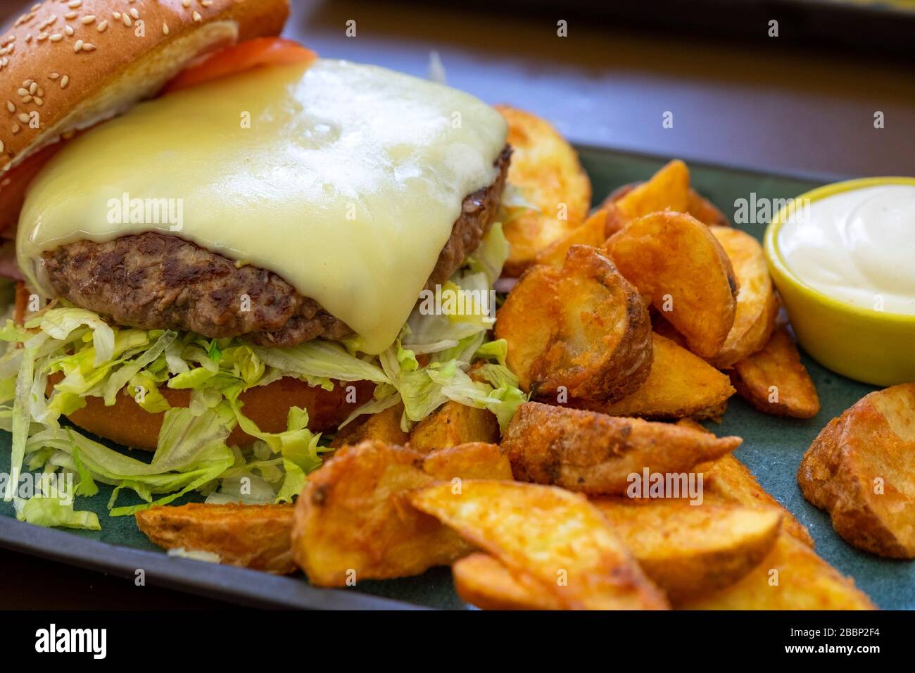 Cheeseburger alla griglia con patatine fritte e maionese Foto Stock