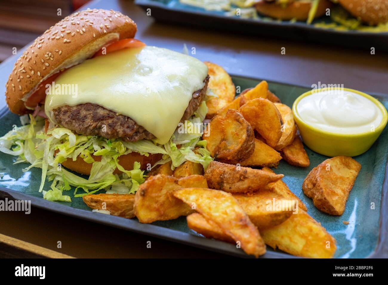 Cheeseburger alla griglia con patatine fritte e maionese Foto Stock