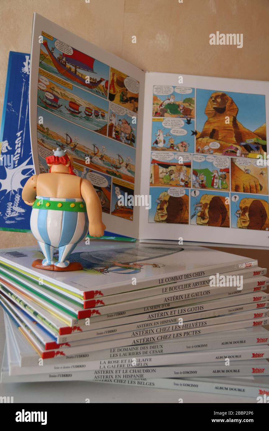 Personaggio Obelix guardando un fumetto di asterix e Obelix, su una pila di fumetti, Francia, Europa. Foto Stock