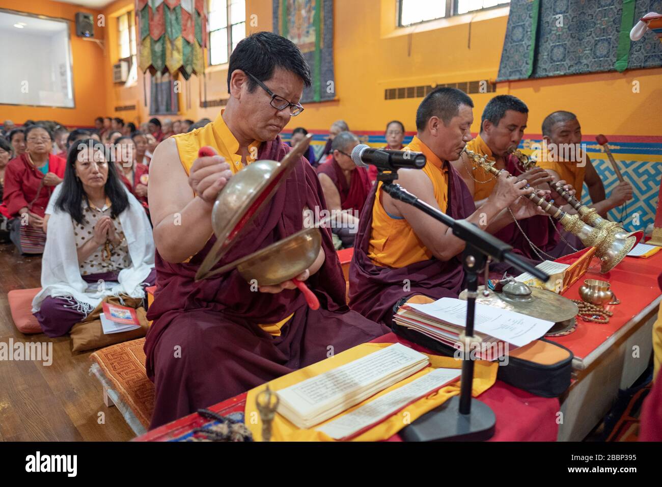 Nepalese monaci buddisti riprodurre strumenti tradizionali durante un servizio di preghiera. Presso lo Sherpa Kyidug tempio di Elmhurst, Queens, a New York City. Foto Stock