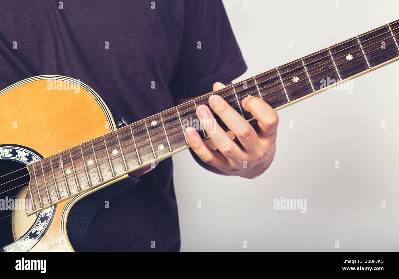 L'uomo gioca chitarra acustica su sfondo bianco close up shot Foto Stock