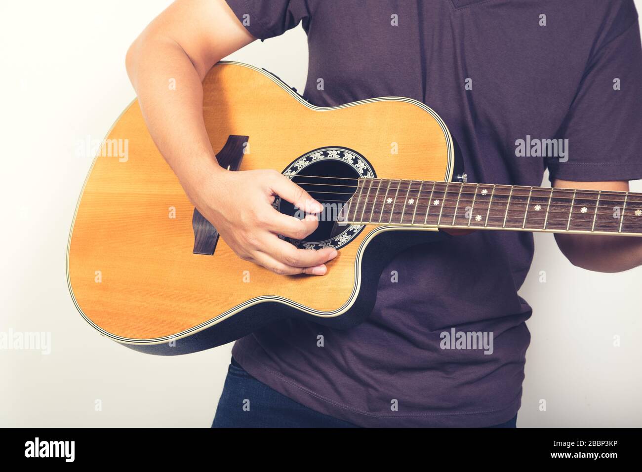 L'uomo gioca chitarra acustica su sfondo bianco close up shot Foto Stock