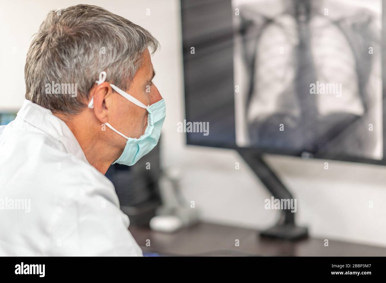 Senior Male Scientist che analizza i dati scientifici guardando la visualizzazione in un laboratorio moderno. Foto Stock