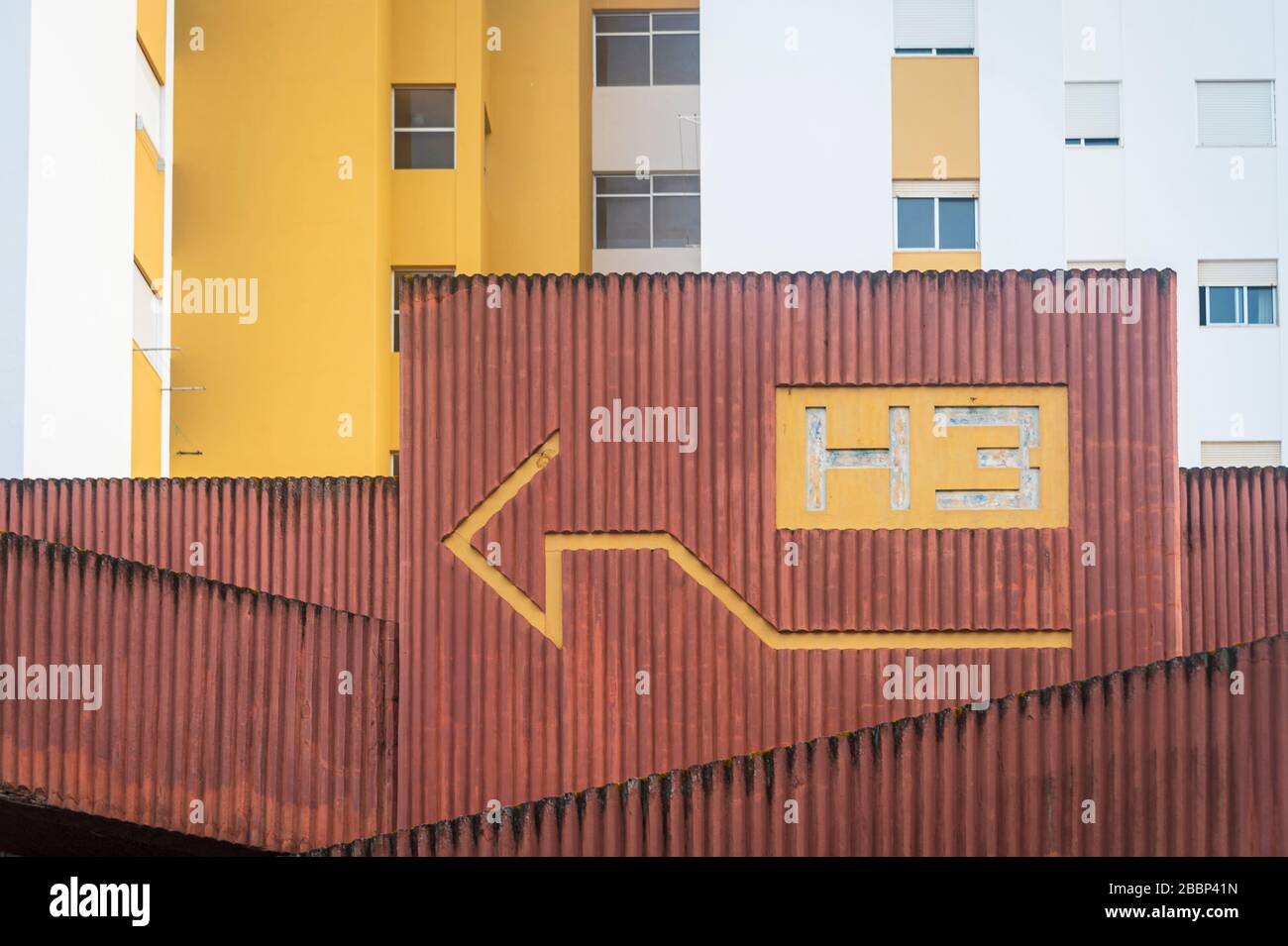blocco di appartamenti in cemento urbano con freccia dipinta sulla parete. Foto Stock