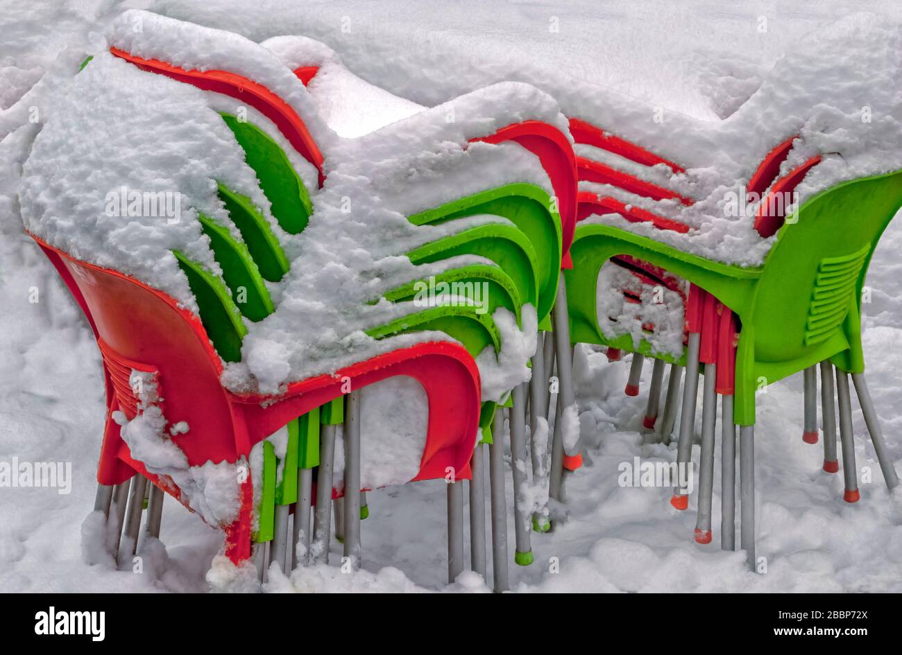 Sedie da giardino accatastate di neve; Foto Stock