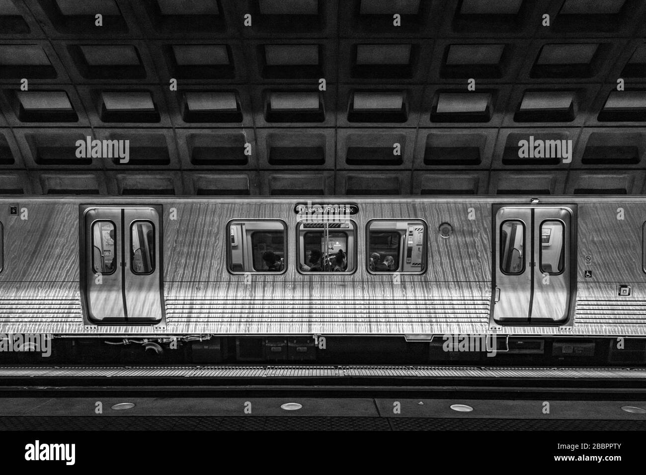 Un treno della metropolitana linea Orange Vienna/'Fairfax si trova sotto il soffitto a cassettoni in cemento della McPherson Square Station, Washington DC. Foto Stock