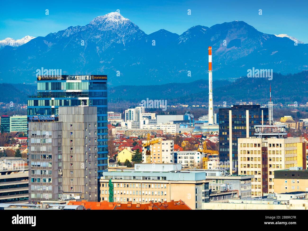 Lubiana - dicembre 2019, Slovenia: Vista degli edifici moderni nel centro di Lubiana con le splendide Alpi innevate sullo sfondo Foto Stock