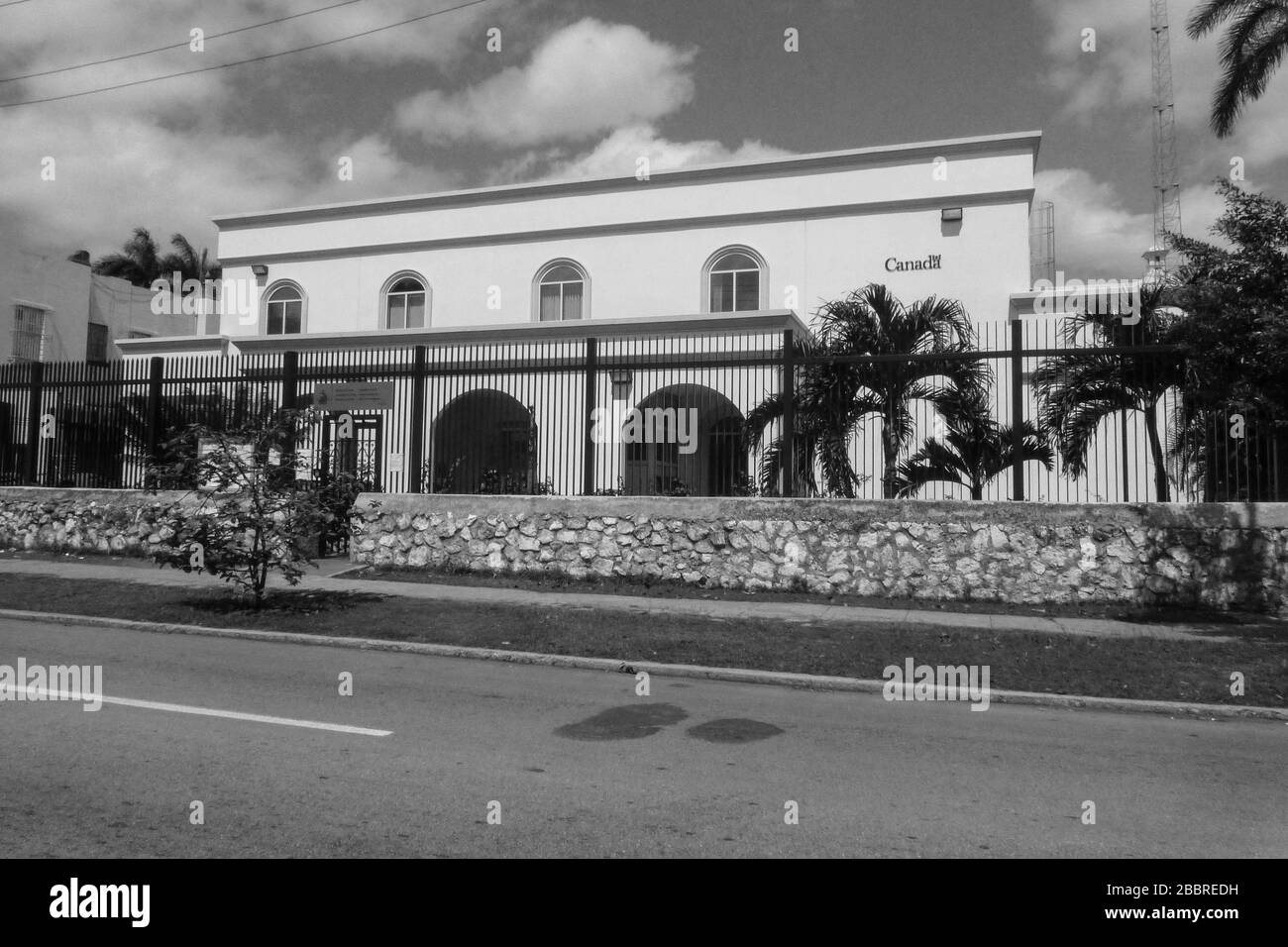 L'ambasciata canadese Havana Cuba alberi palme bianco cancelli cancelli in metallo nero alto protetto da nuvole di pietra edificio governativo nuvola Foto Stock