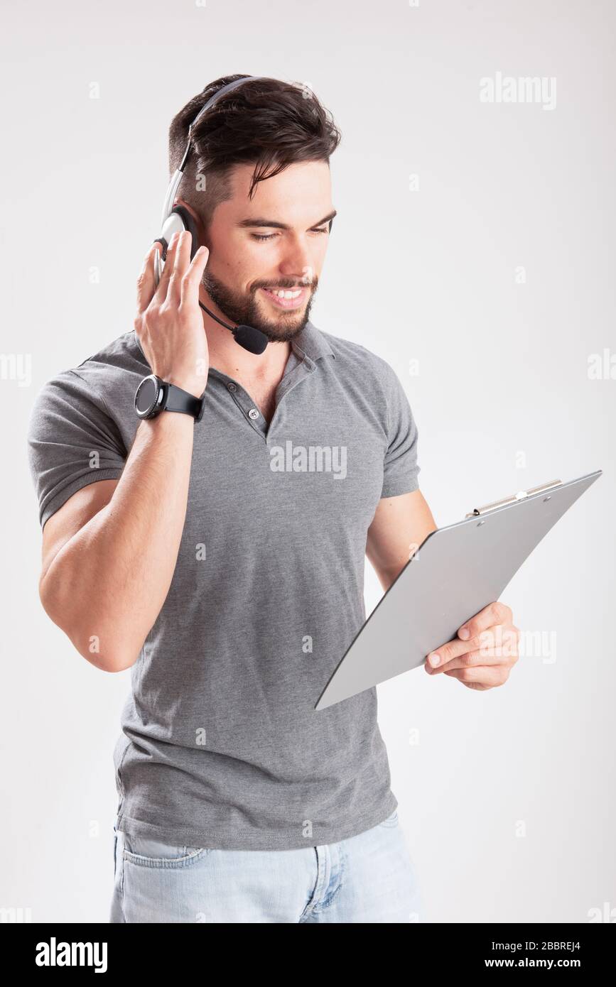 Sorridente giovane addetto alla consegna che tiene e tiene un portadocumenti Foto Stock