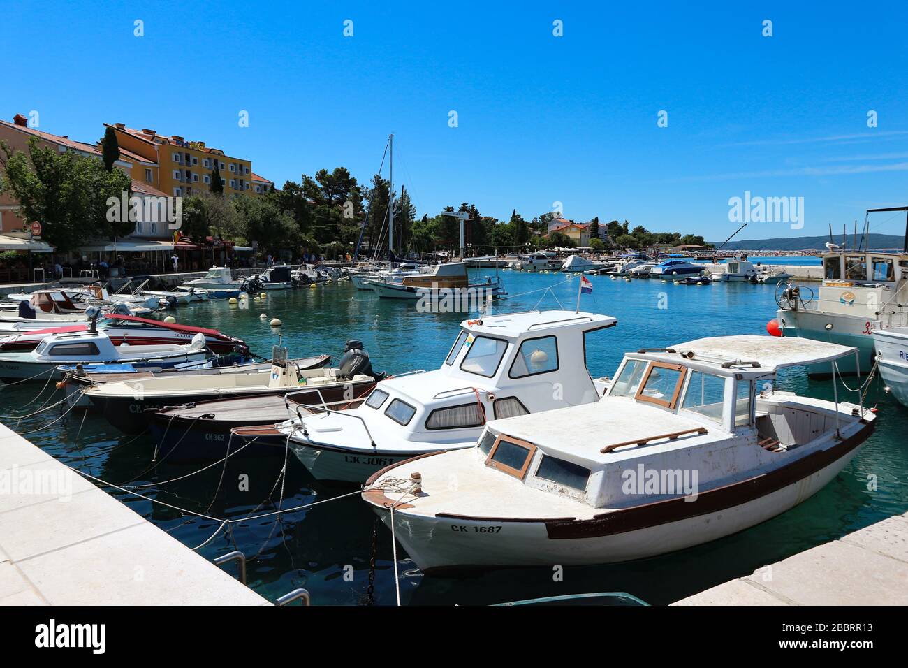 Piccola città di Selce e barche da pesca nel porto Foto Stock