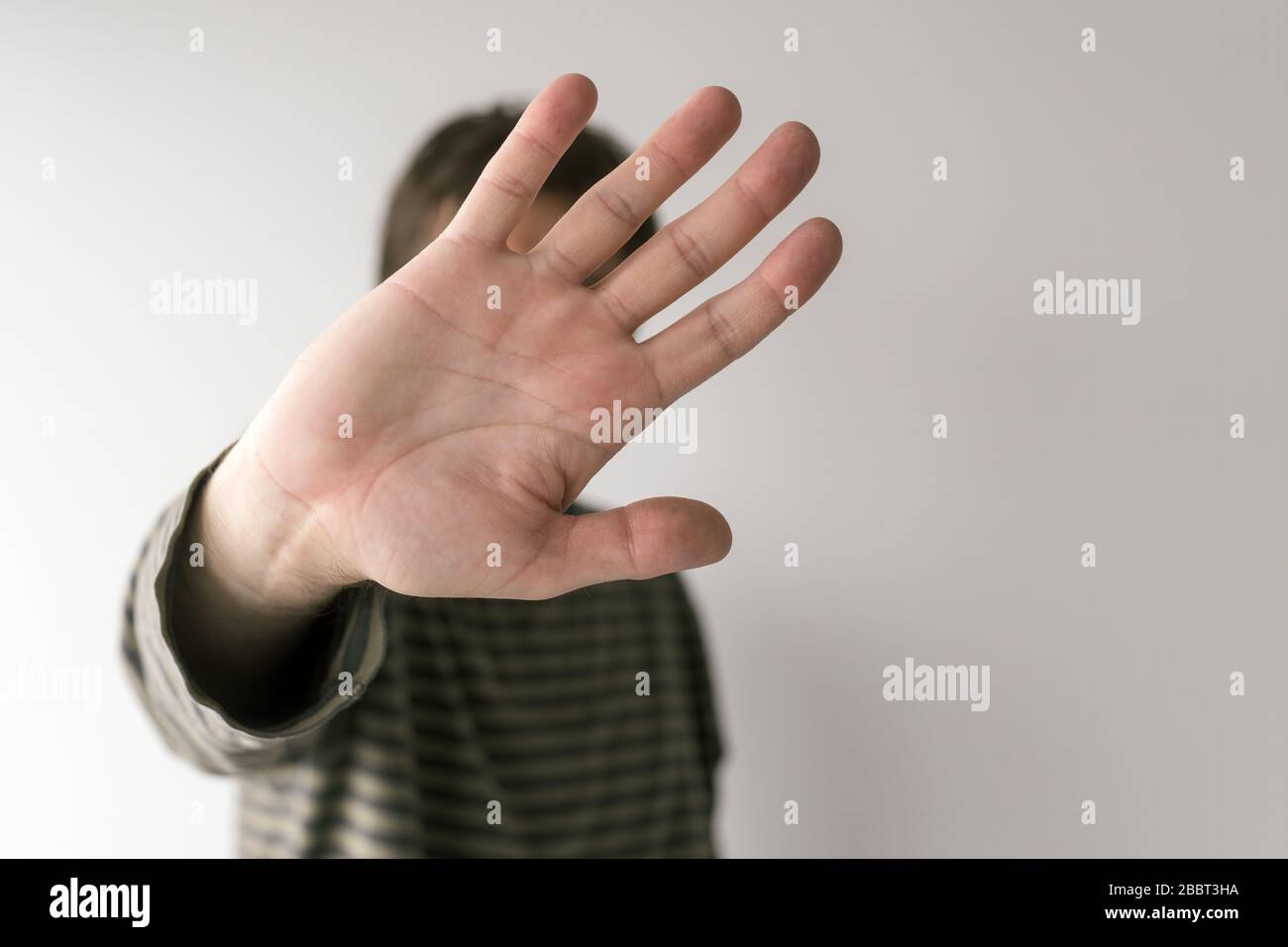 Distanziamento sociale durante il concetto di focolaio di virus, l'uomo gesturante stop sign, fuoco selettivo sulle mani Foto Stock
