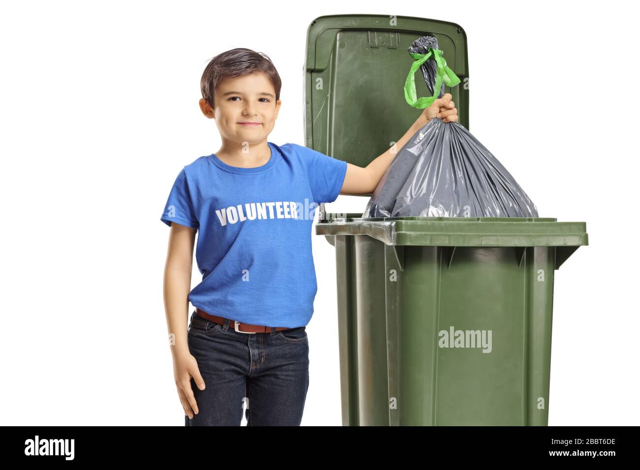 Il volontario del bambino gettando un sacchetto di spreco in un cestino isolato su fondo bianco Foto Stock