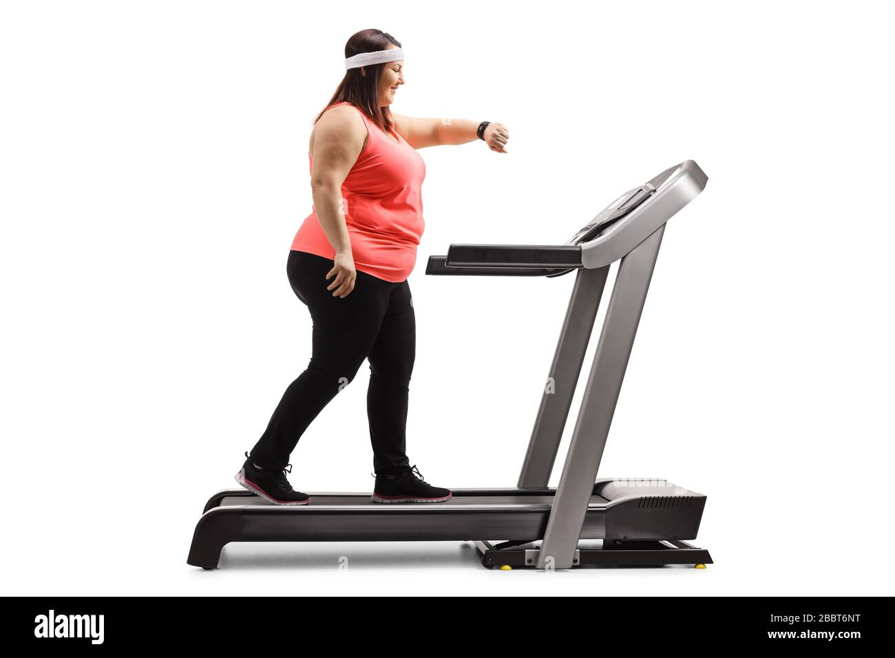 Donna in sovrappeso che esercita su una pedana mobile e che guarda la fascia intelligente del braccio isolata su sfondo bianco Foto Stock