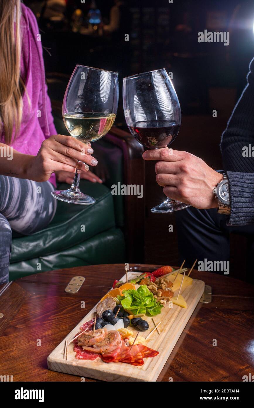 Una coppia festeggia in un bar - ristorante con alcuni drink e gorceries Foto Stock