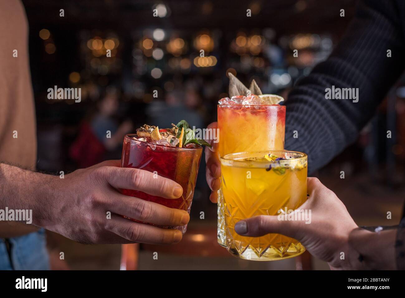 Amici dopo aver lasciato il lavoro festeggiate in un bar - ristorante con qualche drink Foto Stock