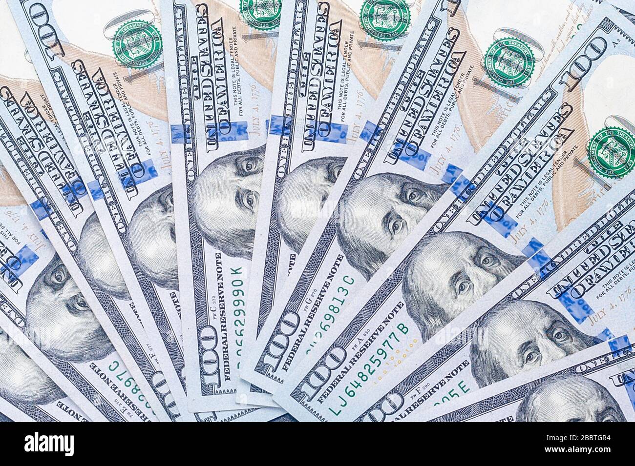 Un frammento ingrandito di molti nuovi conti americani da cento dollari con un ritratto del presidente Benjamin Franklin Foto Stock