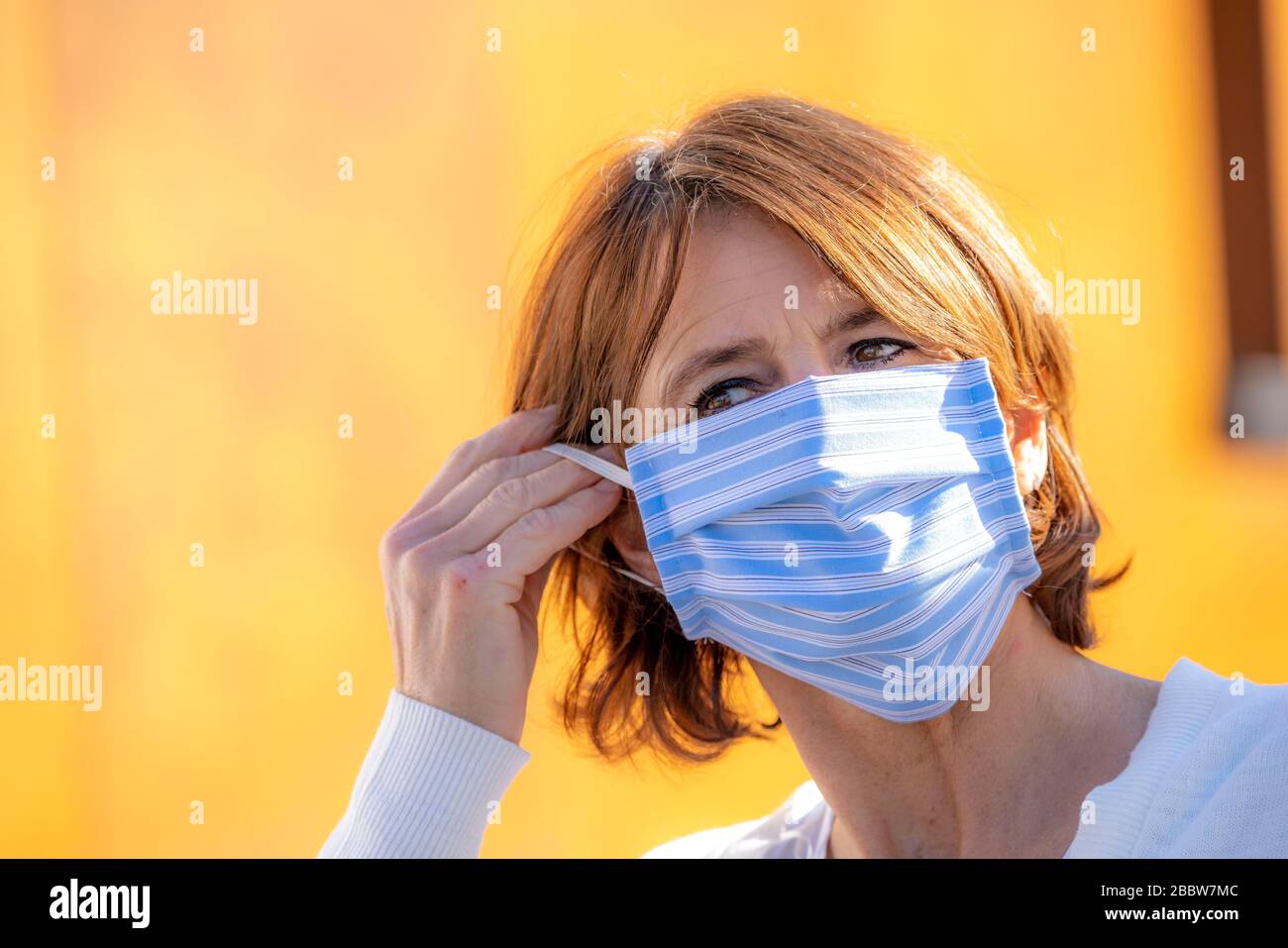 Donna che indossa una maschera respiratoria, cucita in cotone, effetti della crisi corona in Germania, Foto Stock