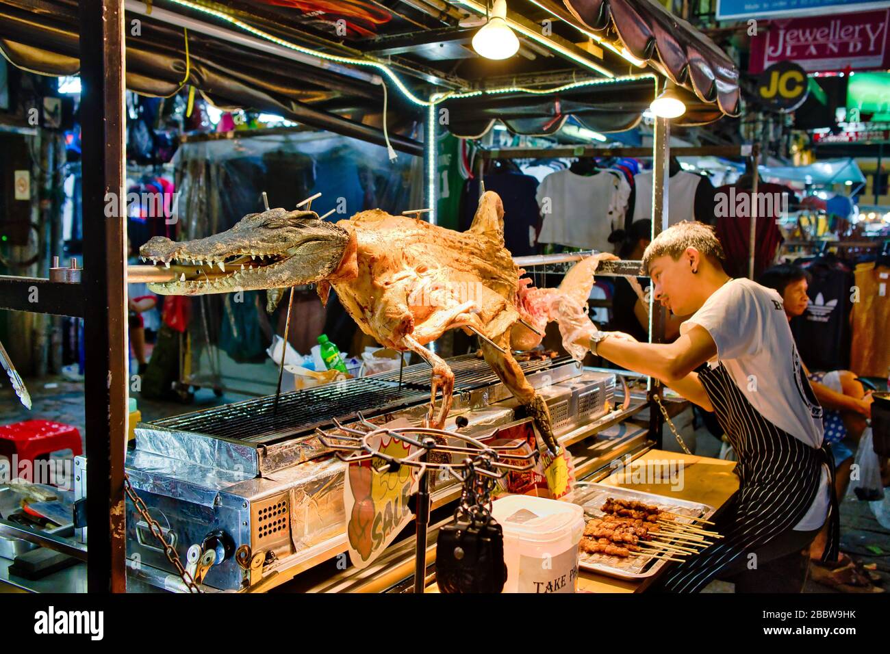 Un venditore di strada sta vendendo spiedini cocodrilli a khao san Road a bangkok, Thailandia. Foto Stock