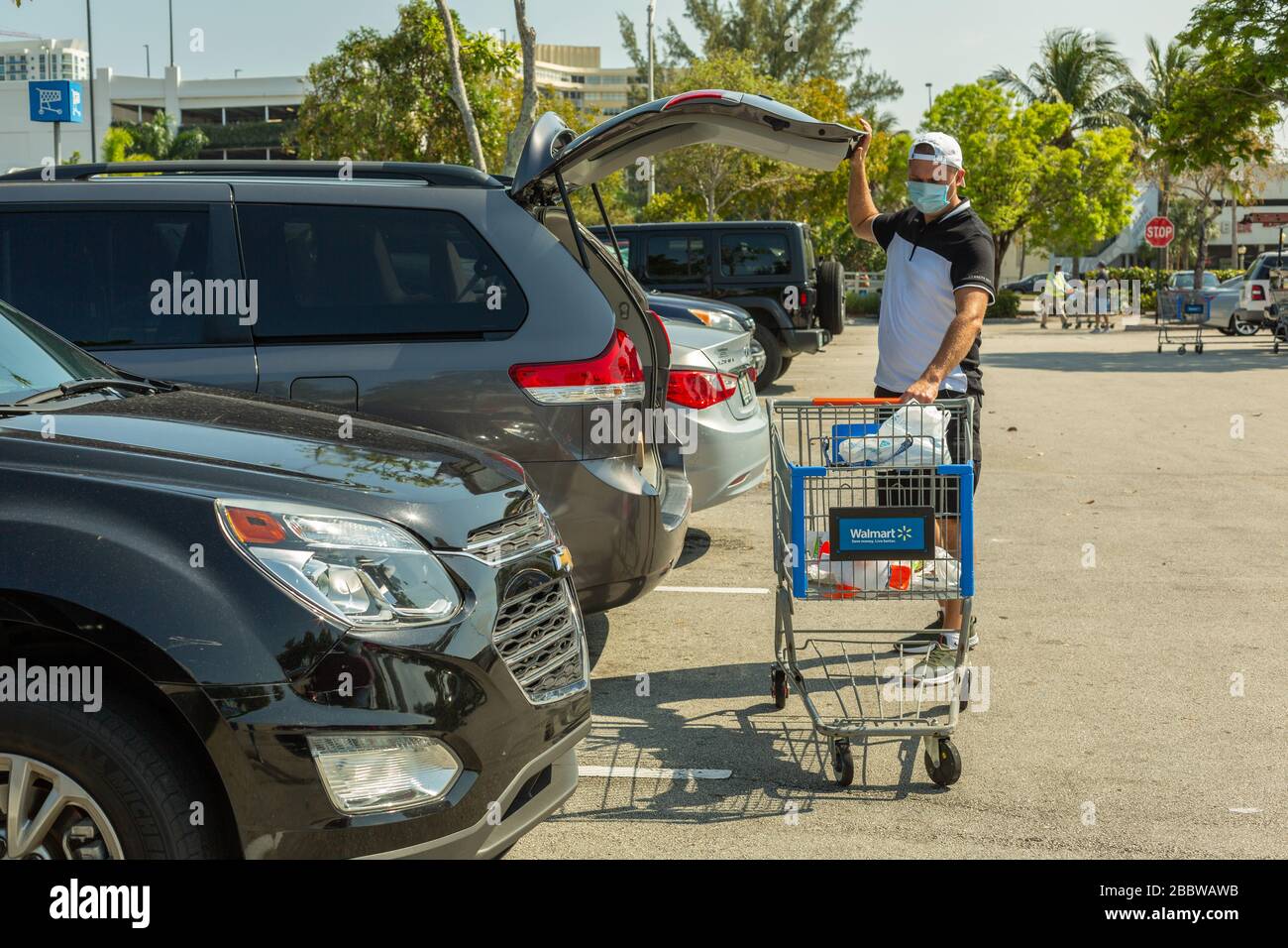 Uomo che indossa la maschera medica sul Walmart negozio spazio parcheggio. Tempo di quarantena per Coronavirus. Foto Stock