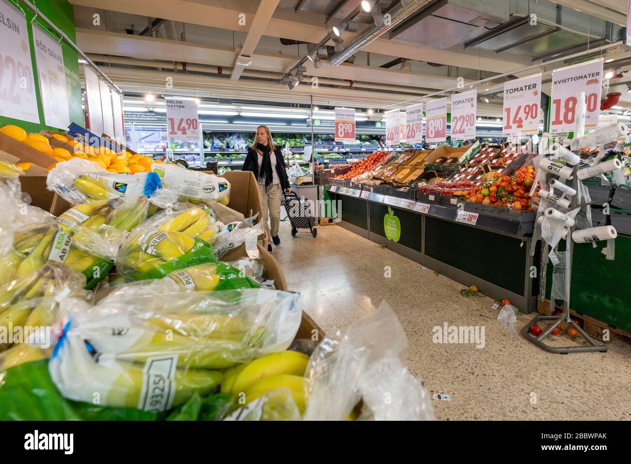 Donna che naviga nella produzione di frutta e verdura Aisle presso la catena di alimentari Willys a Gothenburg, Svezia, Europa Foto Stock