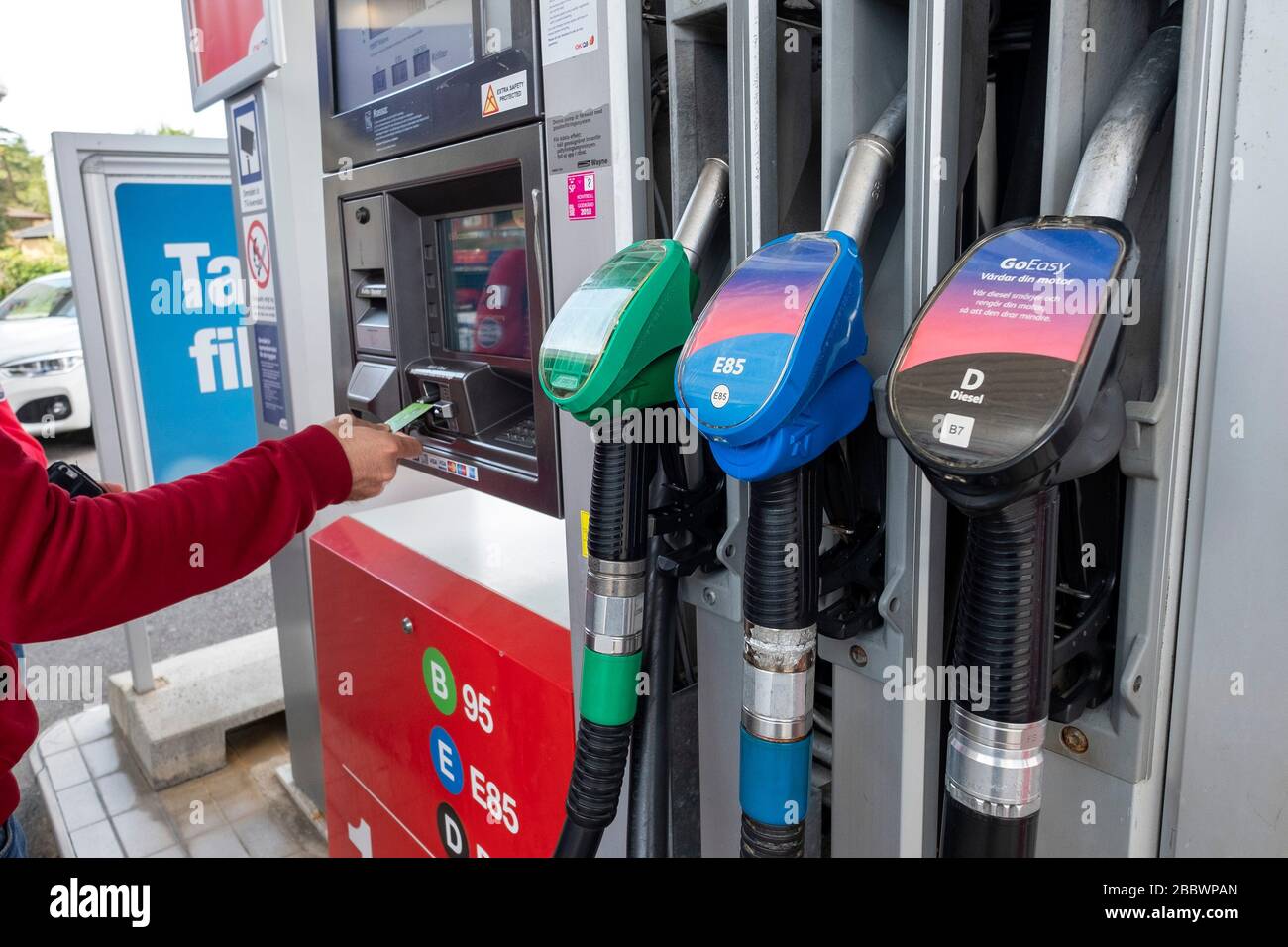 Cliente che utilizza una carta di credito per pagare la benzina presso una pompa a gas a Gothenburg, Svezia, Europa Foto Stock