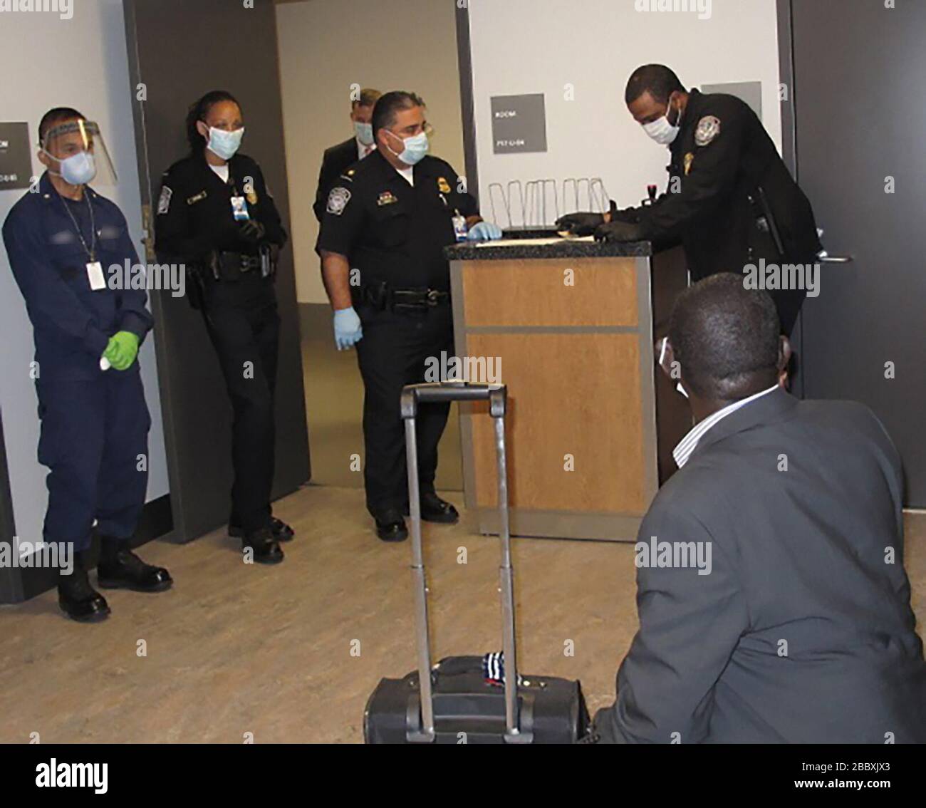 I funzionari delle dogane e della protezione dei confini degli Stati Uniti all'aeroporto internazionale Hartsfield-Jackson di Atlanta effettuano una migliore selezione dei passeggeri di un viaggiatore internazionale che ha visitato recentemente la Guinea. Lo screening avanzato dei passeggeri, iniziato ad Atlanta il 16 ottobre, include l'isolamento del viaggiatore mentre i funzionari CBP ottengono ulteriori informazioni. Foto Stock