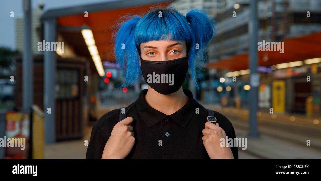 maschera viso medico alla moda coronavirus indossata da giovane studentessa con capelli blu in stile anime. Fermare la diffusione del virus covid 19 o il concetto di inquinamento atmosferico Foto Stock