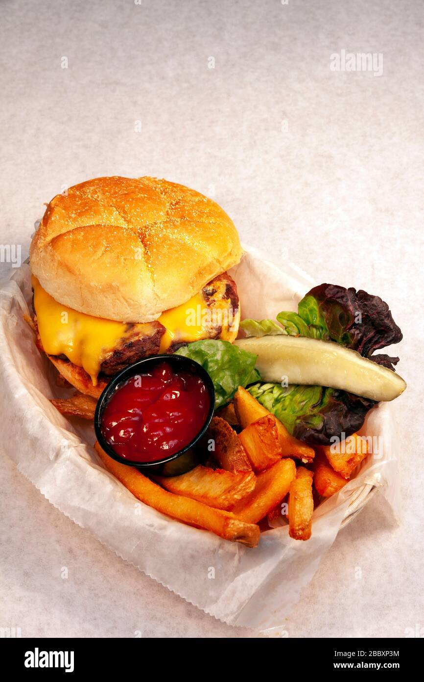 Cheeseburger con patatine fritte, condimenti, di James D Coppinger/Dembinsky Foto Assoc Foto Stock
