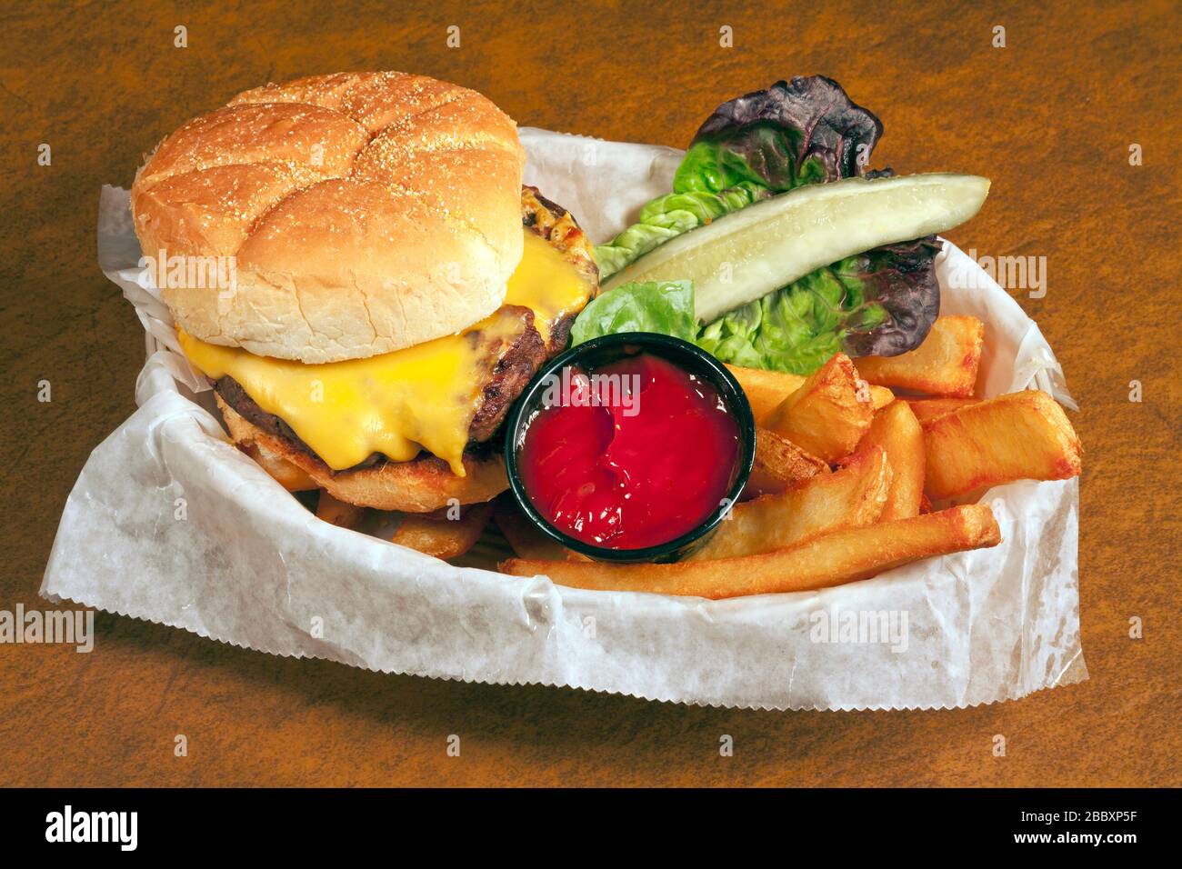 Cheeseburger con patatine fritte, condimenti, di James D Coppinger/Dembinsky Foto Assoc Foto Stock