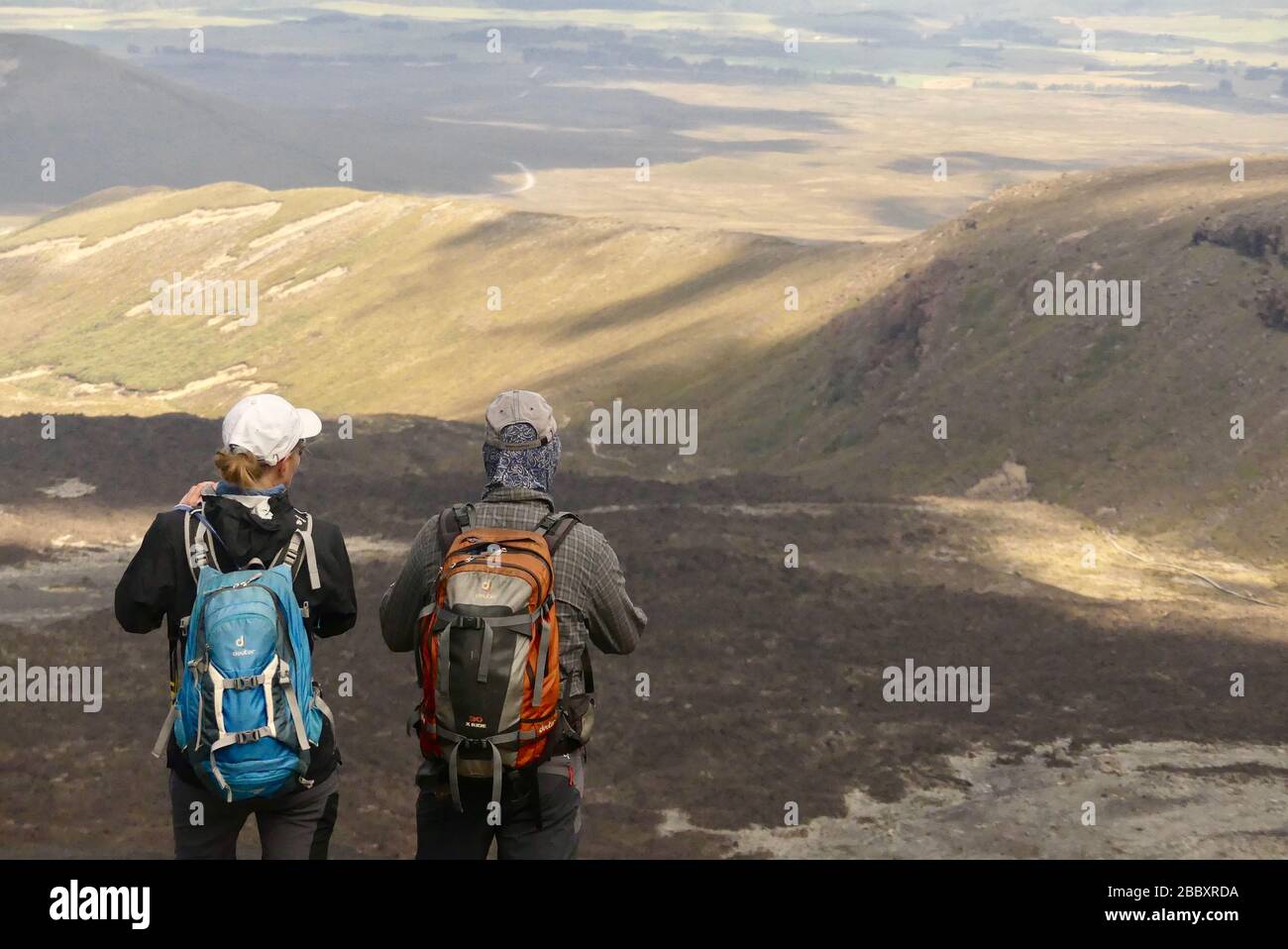Due escursionisti che si affacciano sul Parco Nazionale di Tongariro sulla pista di attraversamento delle Alpi Foto Stock
