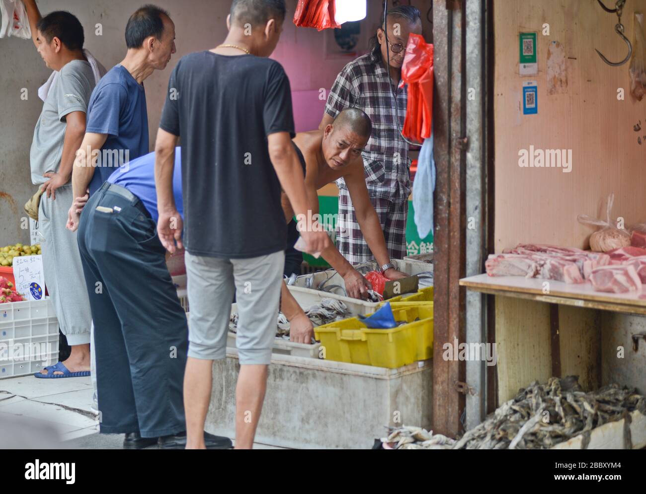 Uomini cinesi in un negozio di pesce nella città vecchia di Shanghai. Huangpu. Cina Foto Stock