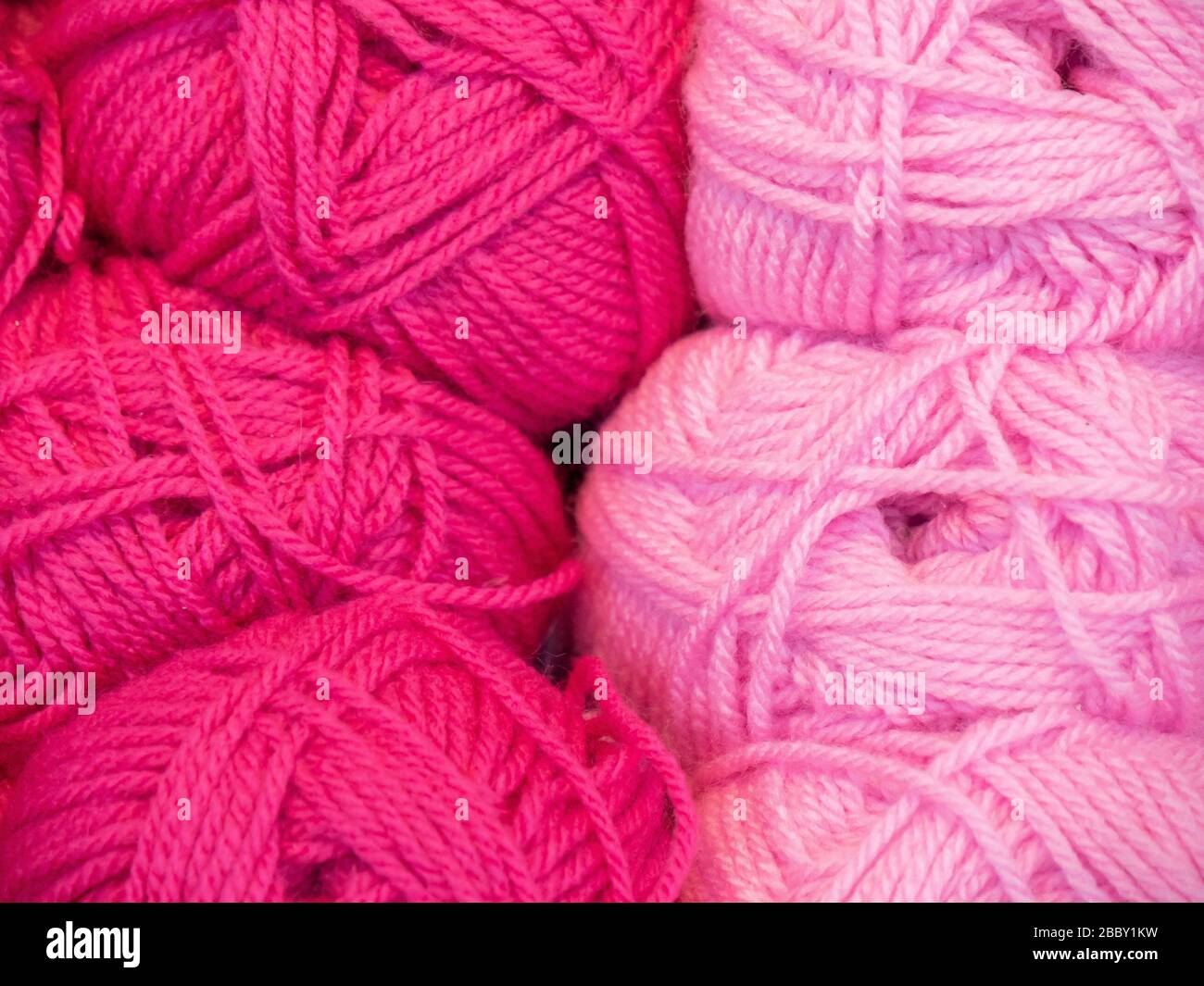 Palline rosa di filo di lana materiale per artigianato tessile hobby, colorato trama astratto sfondo Foto Stock