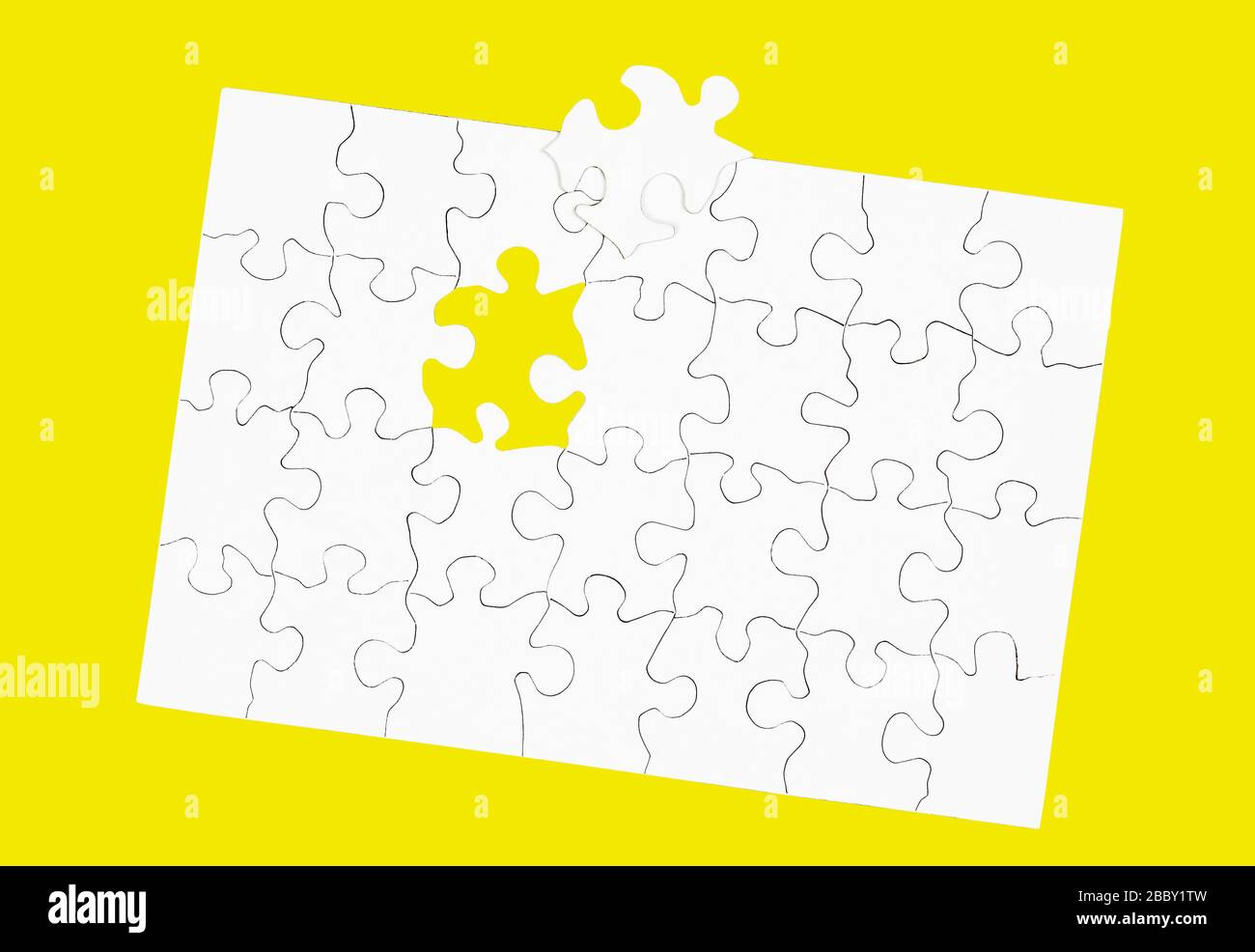 Bianco puzzle bianco vuoto con un pezzo mancante isolato su giallo Foto Stock