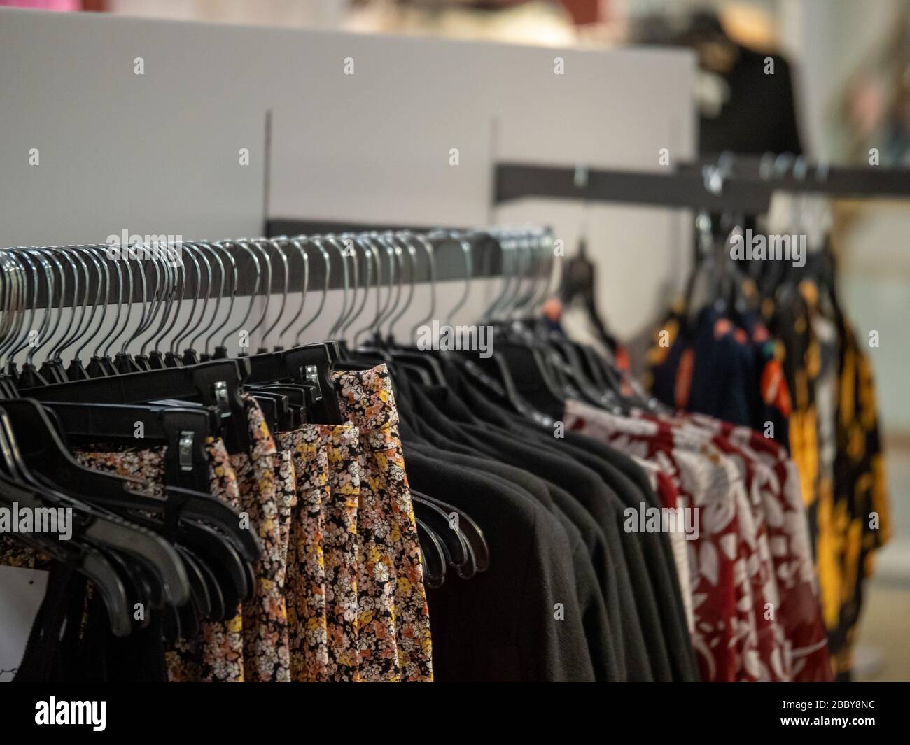 Un certo numero di capi di abbigliamento femminili a motivi floreali su un  appendiabiti in un negozio di abbigliamento firmato Foto stock - Alamy
