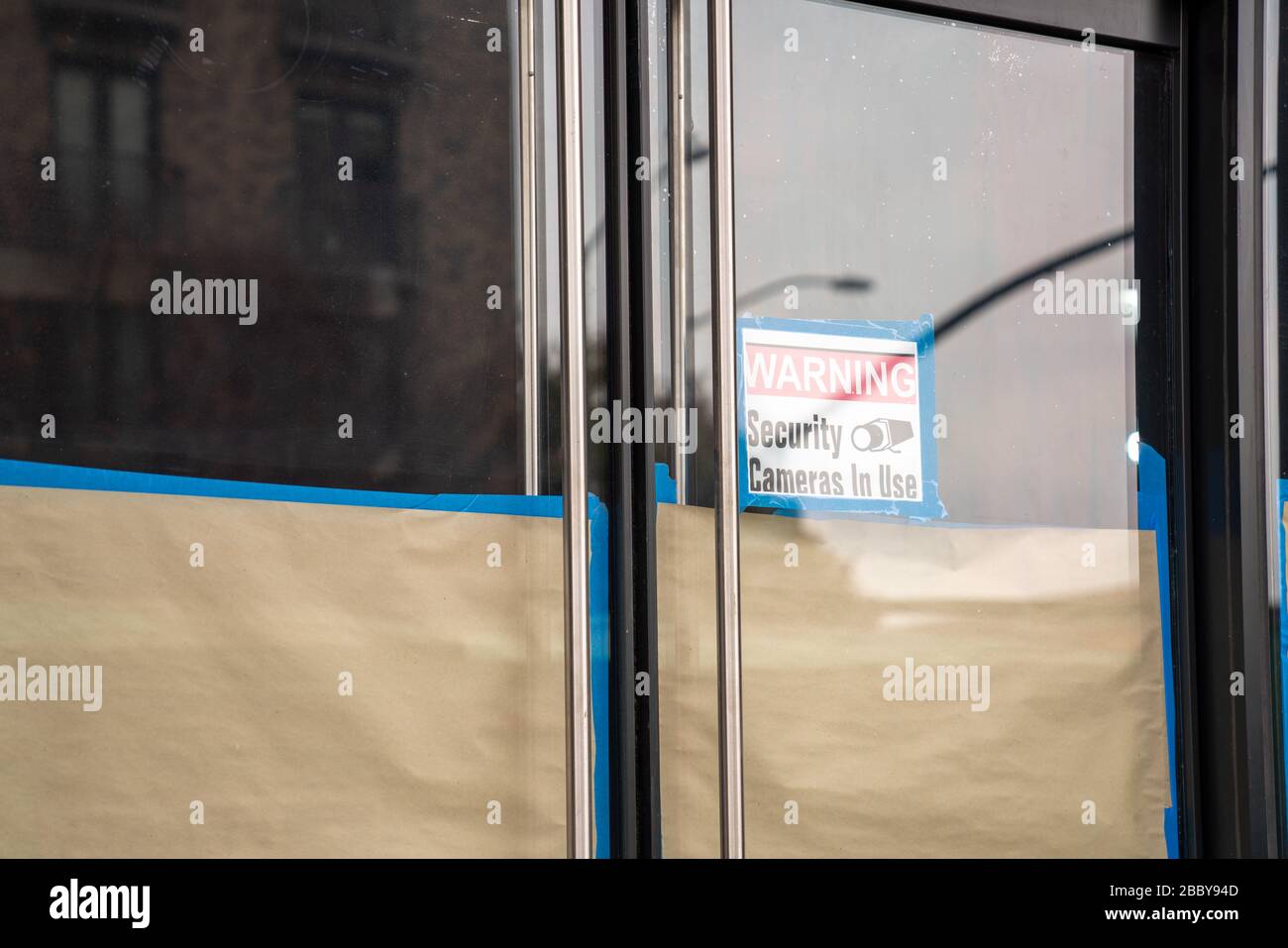 Avvertenza le telecamere di sicurezza in uso firmano sulla porta di vetro a bordo nell'edificio di riparazione Foto Stock